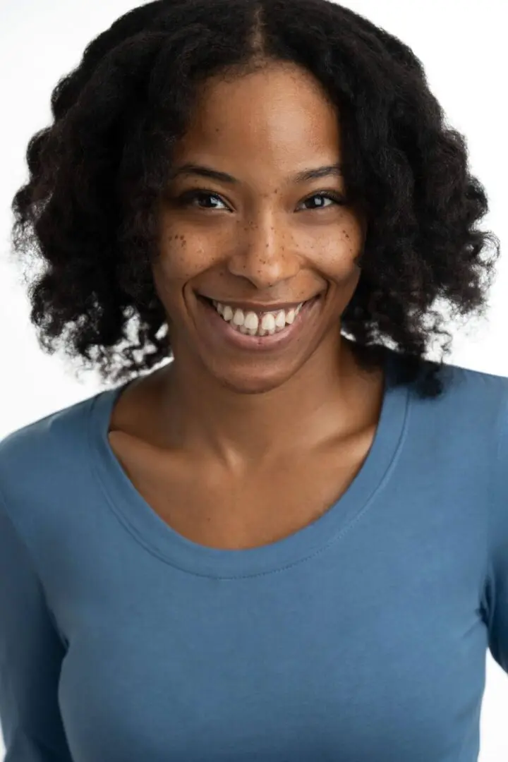 Smiling woman with curly hair and freckles