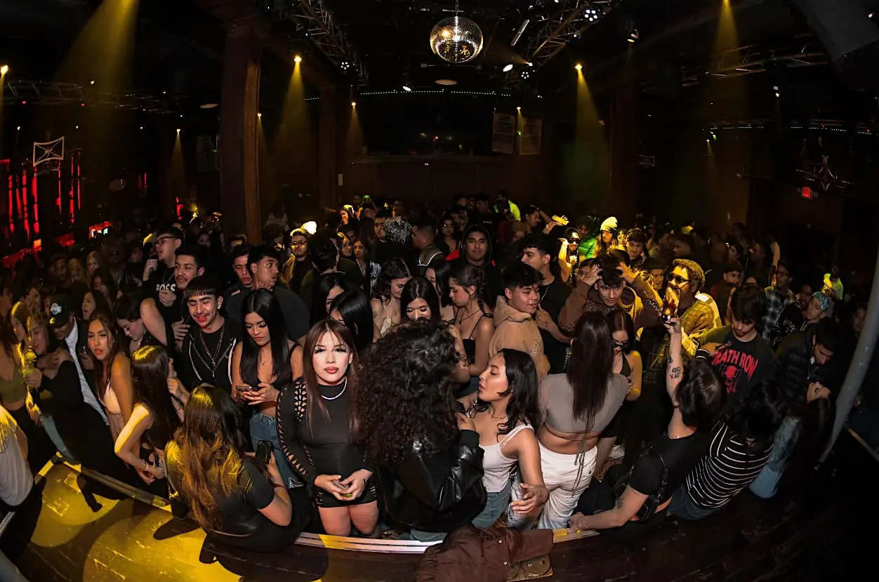 Crowded nightclub dance floor with disco ball