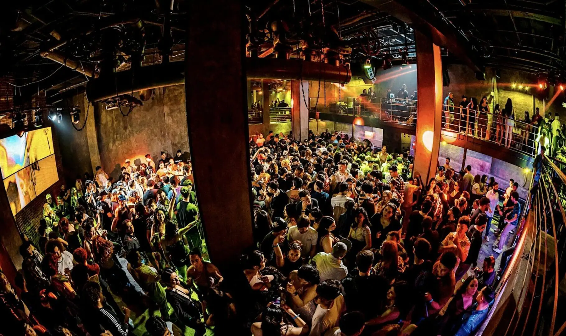 Crowded nightclub dance floor with colorful lights