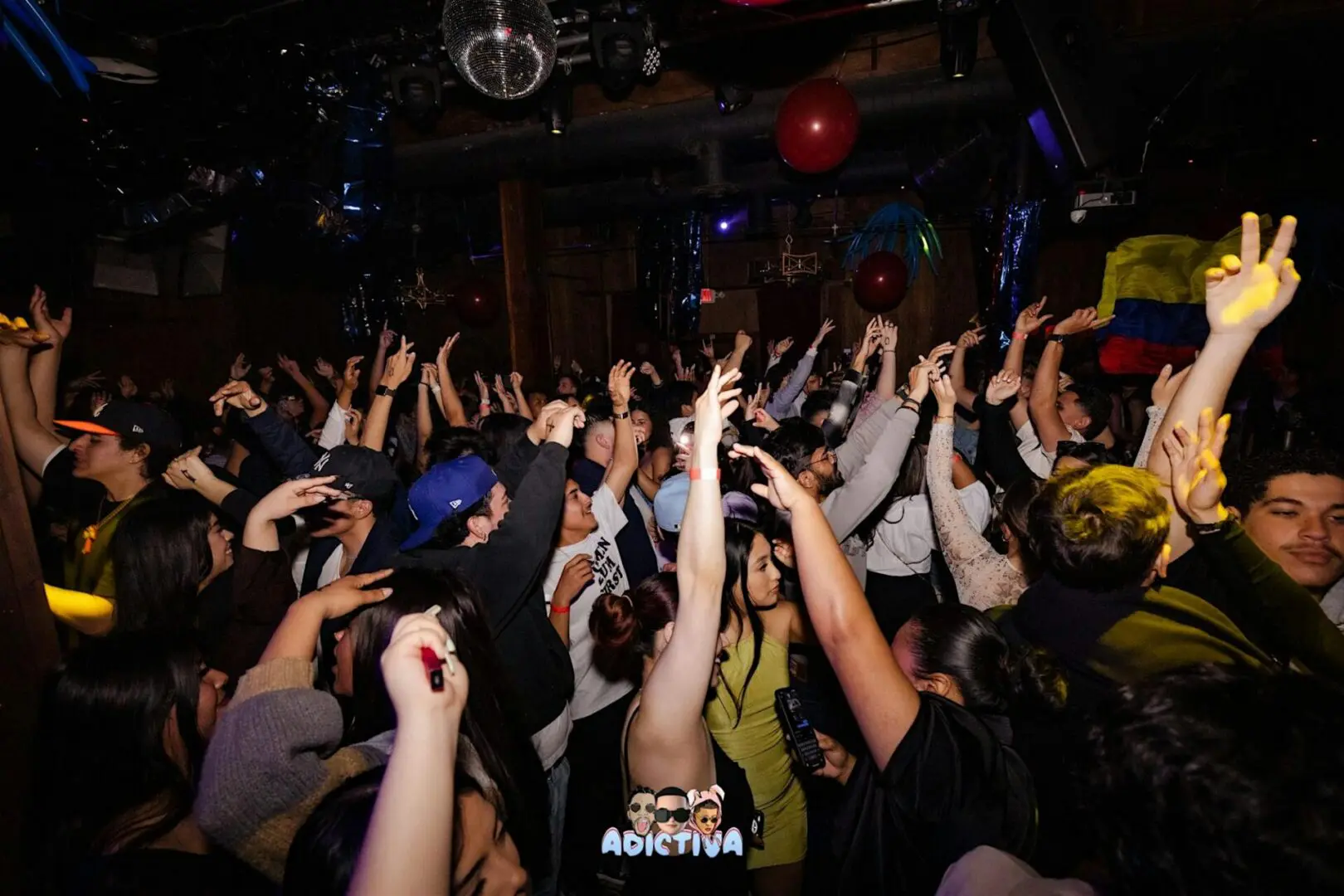 Crowded nightclub dance floor with raised hands