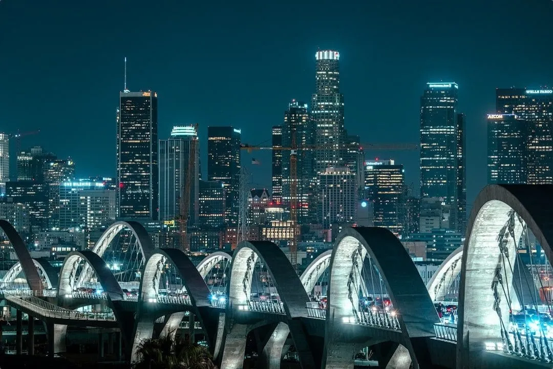 Nighttime Los Angeles skyline with arched bridge